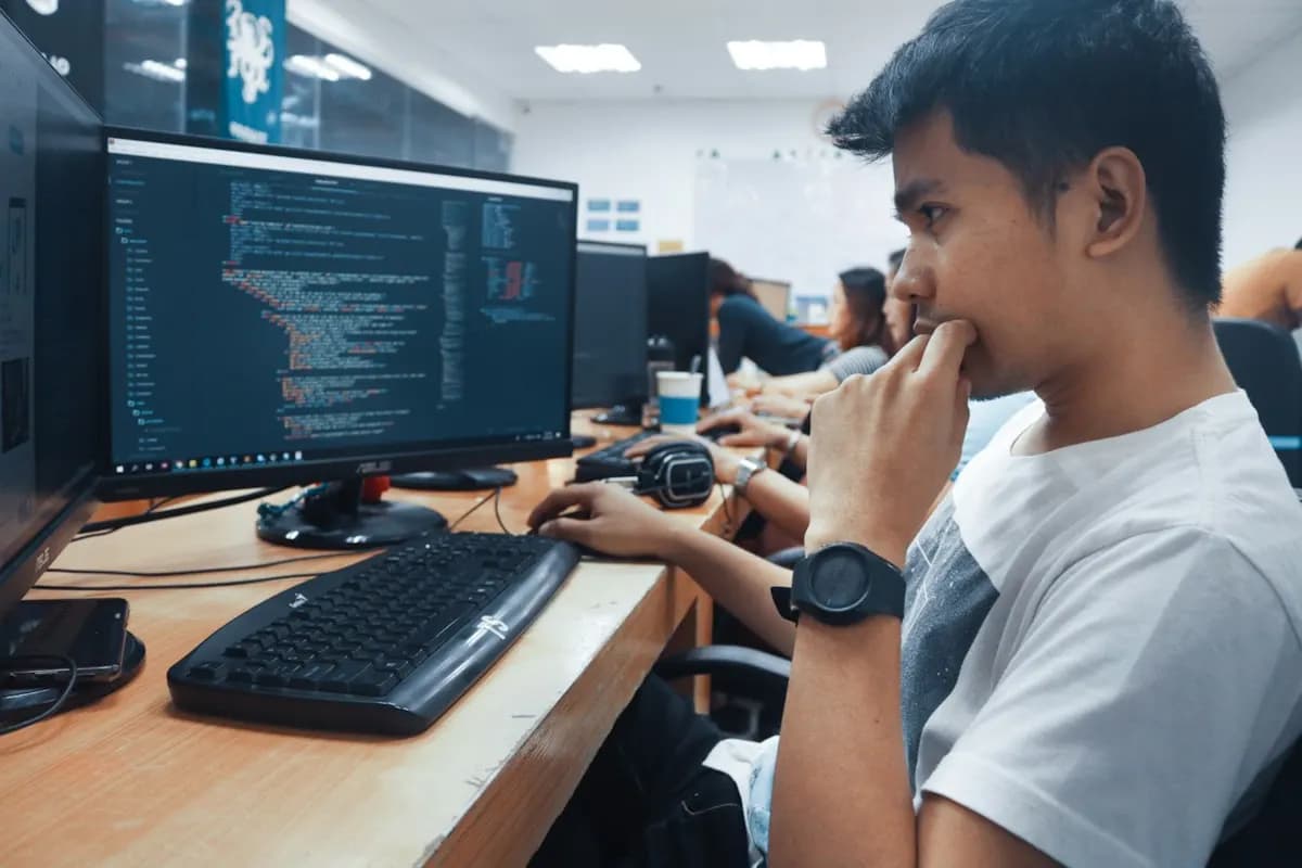 Young engineer working at multiple monitors in a startup office