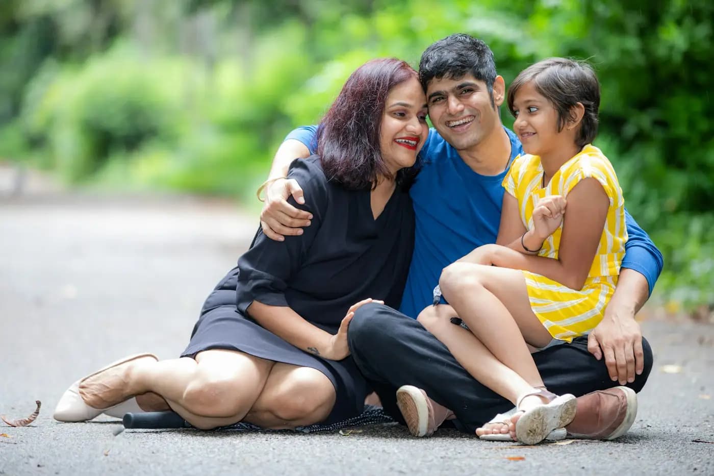Indian family of three sitting together outdoors