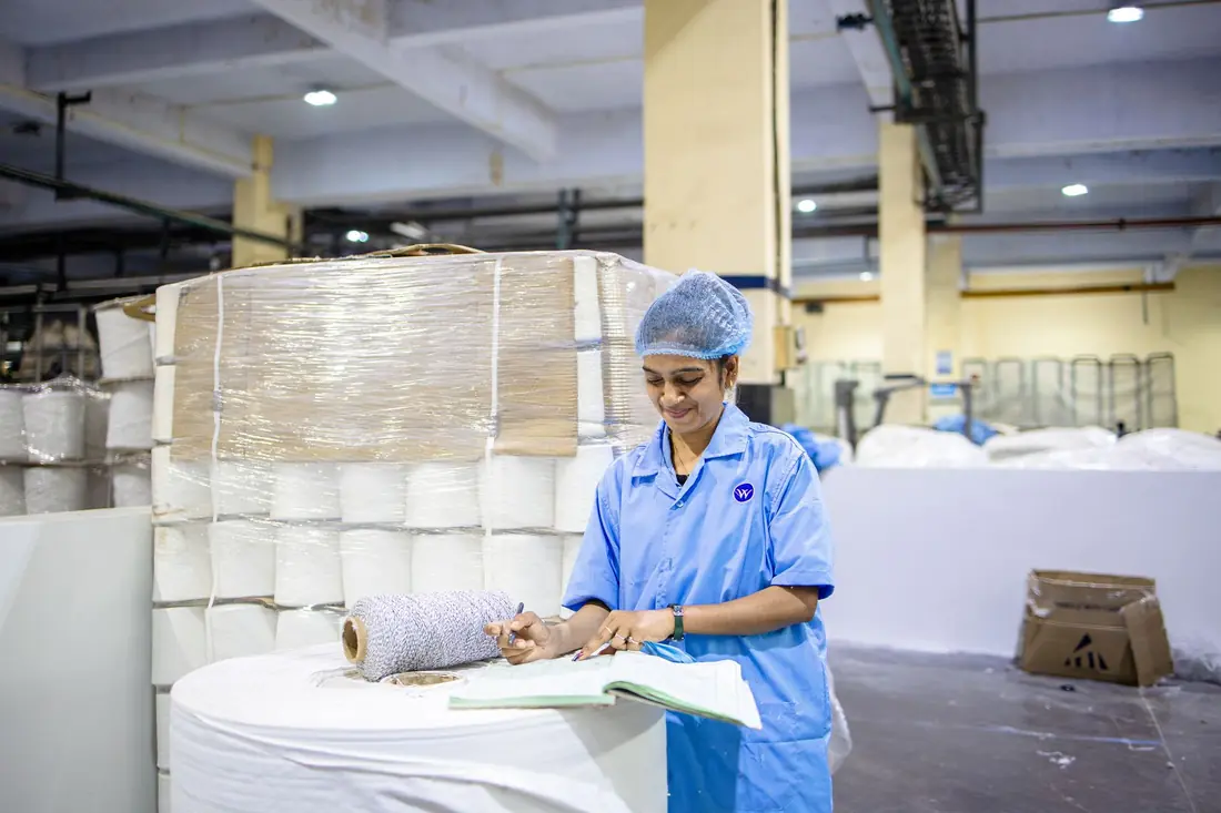 A factory worker recording production details on a clipboard