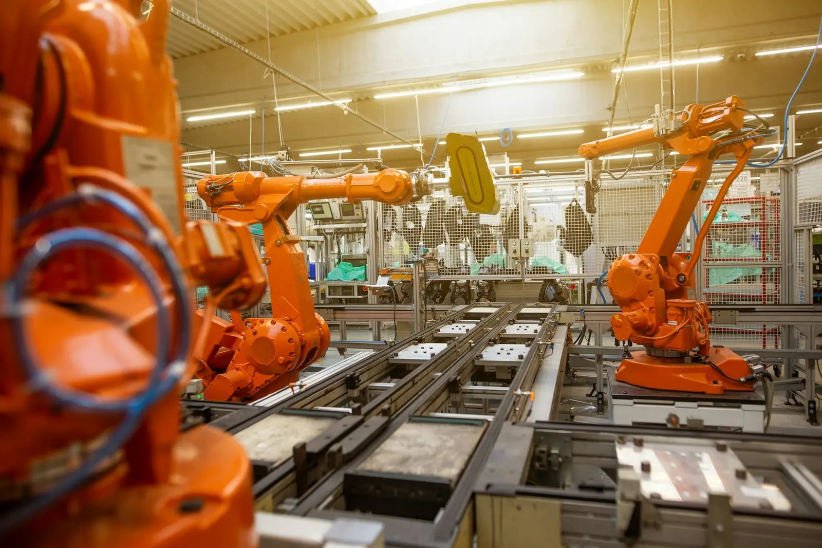 Orange robotic arms on an automotive production line