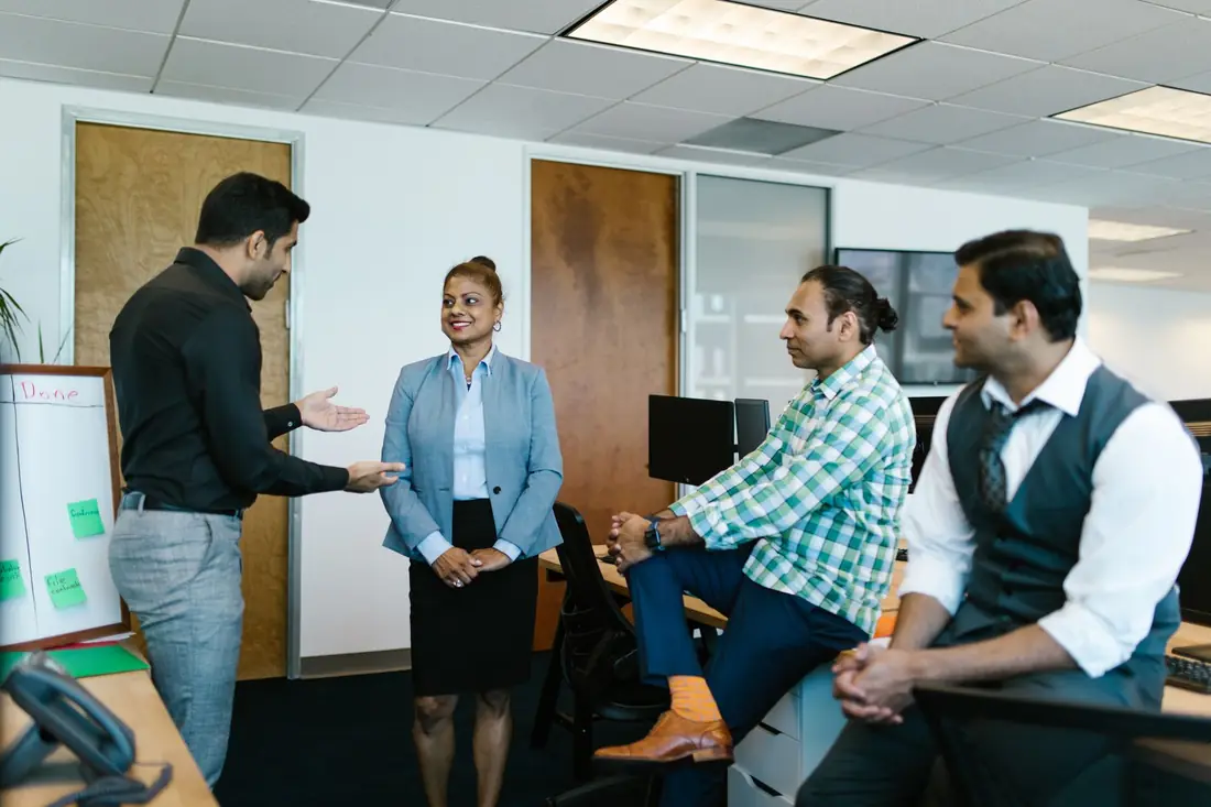 A manufacturing leadership team talking in an office